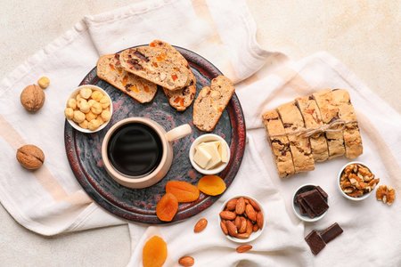 Composition with tasty biscotti cookies, cup of coffee, nuts and chocolate on light backgroundの写真素材