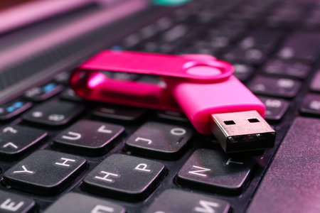 Pink USB flash drive on modern laptop, closeupの写真素材