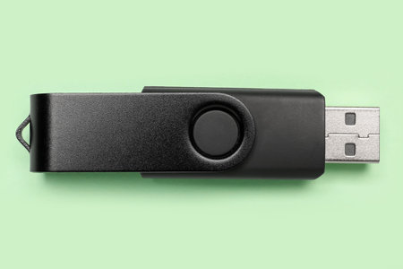 Black USB flash drive on green background
