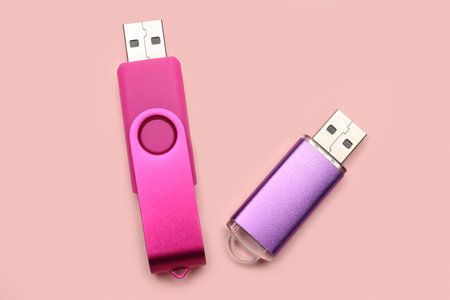 USB flash drives on pink background
