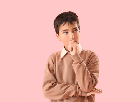Little boy biting nails on pink backgroundの写真素材