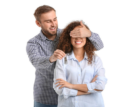 Happy young couple with key on white backgroundの写真素材