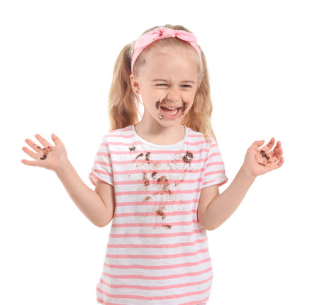 Little girl with chocolate stains on her clothes against white backgroundの写真素材