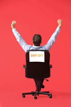 Young businessman relaxing on chair against color background. day off conceptの写真素材