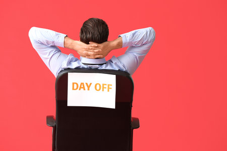Young businessman relaxing on chair against color background. day off conceptの写真素材