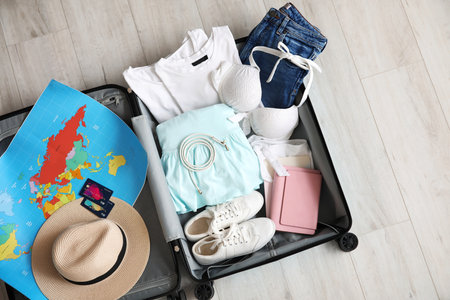Open packed suitcase on wooden backgroundの写真素材