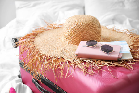 Packed suitcase and travel accessories on bed in roomの写真素材