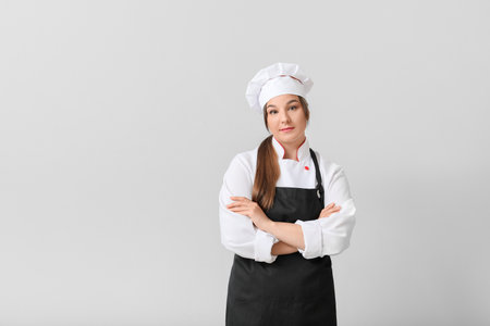 young female chef on light backgroundの写真素材