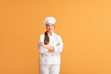 Young female chef on color backgroundの写真素材