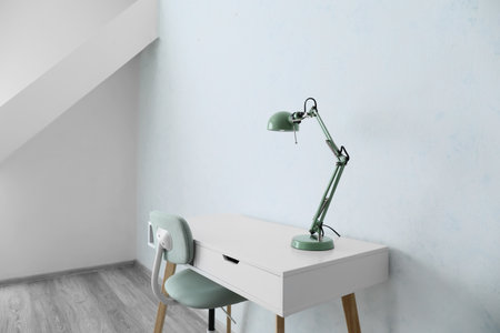 Table with lamp and chair in empty roomの写真素材