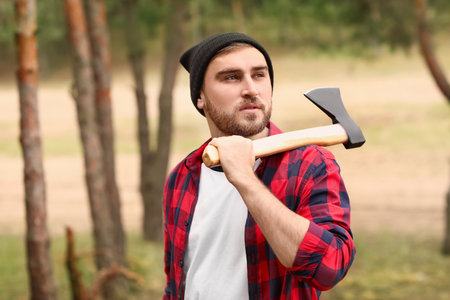 Handsome lumberjack with ax in the forestの写真素材