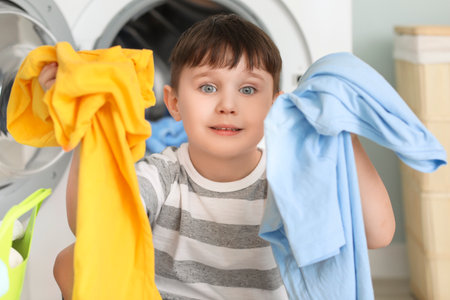 Little boy with dirty clothes at homeの写真素材