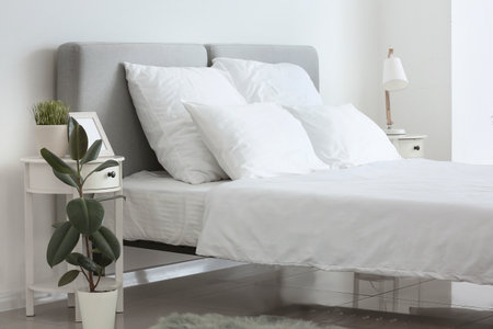 Big comfortable bed with clean linen in roomの写真素材