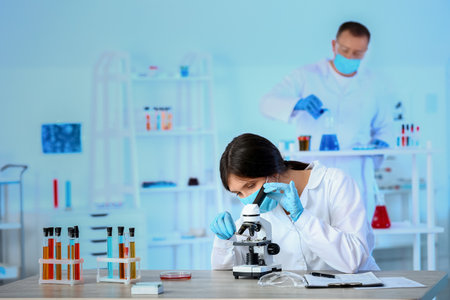 Scientist working with microscope in laboratoryの写真素材