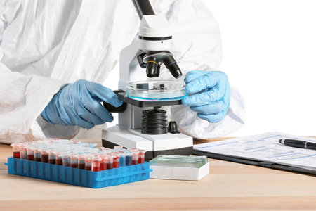 Scientist working with microscope against white backgroundの写真素材