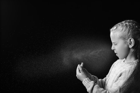 Black and white portrait of coughing little girl on dark backgroundの写真素材