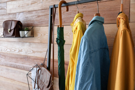 Stylish umbrella with clothes in the interior of the hallの写真素材
