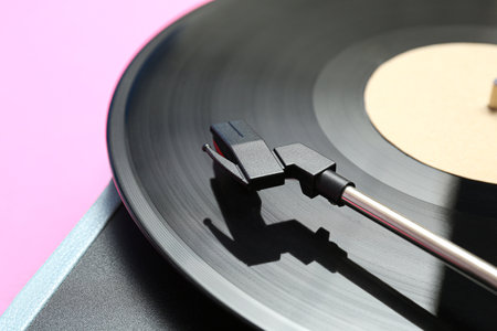Record player with vinyl disk on pink background, closeupの写真素材