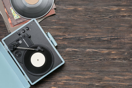 Record player with vinyl disks on dark wooden backgroundの写真素材