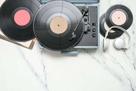 Record player with vinyl disks and headphones on white grunge backgroundの写真素材