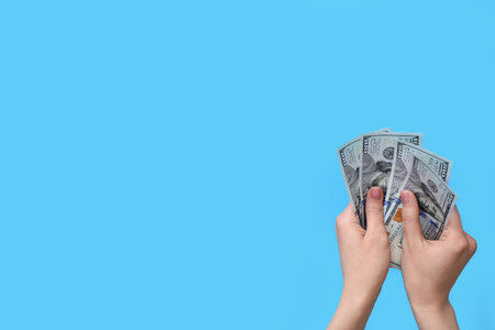 Woman with dollar banknotes on blue backgroundの写真素材
