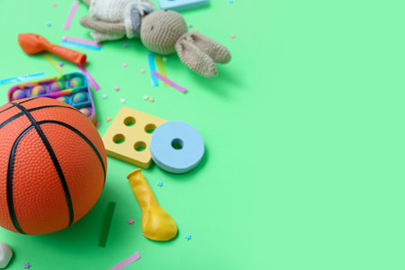 Baby toys with confetti on green background, closeup. Children's Day celebrationの写真素材