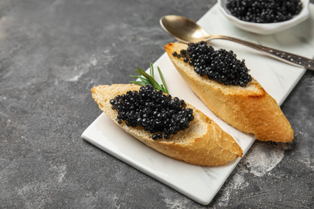 Tasty bruschettas with black caviar on dark grunge backgroundの写真素材