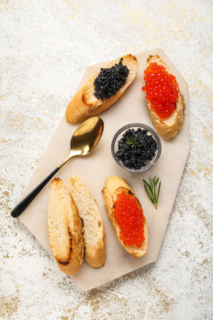 Tasty bruschettas with red and black caviar on light grunge backgroundの写真素材