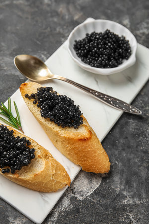 Tasty bruschettas with black caviar on dark grunge backgroundの写真素材