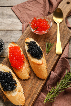 Tasty bruschettas with red and black caviar on wooden backgroundの写真素材