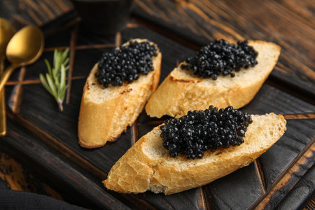 Tasty bruschettas with black caviar on wooden backgroundの写真素材