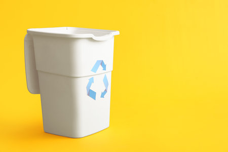 Container for garbage on yellow background. Recycling conceptの写真素材