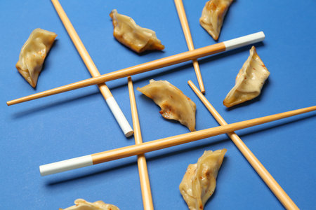 Composition with tasty Chinese jiaozi and chopsticks on blue backgroundの写真素材