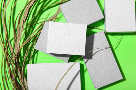 Decorative plaster podiums and dry grass on green background