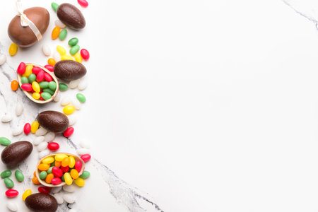 Chocolate Easter eggs with candies on white marble tableの写真素材