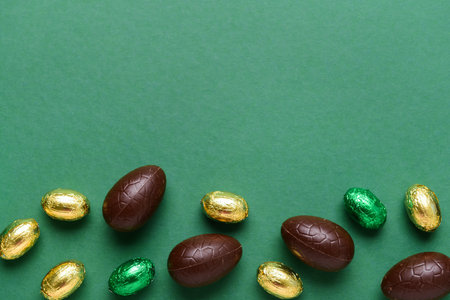 Chocolate Easter eggs and candies on green backgroundの写真素材