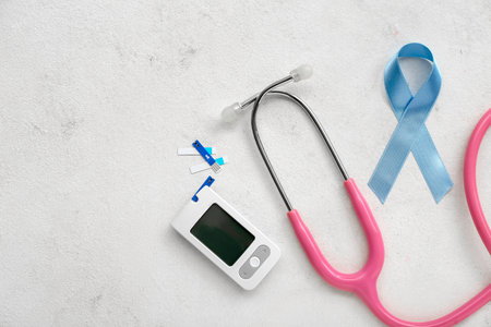 Awareness ribbon with glucometer and stethoscope on white background. Diabetes conceptの写真素材
