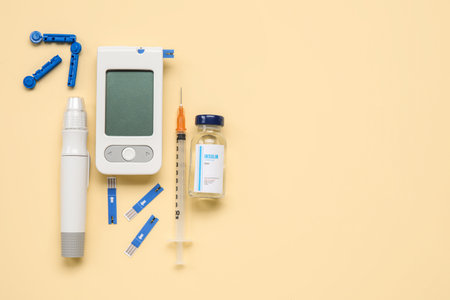 Glucometer with lancet pen, insulin and syringe on beige background. Diabetes conceptの写真素材