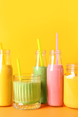 Glasses and bottles of colorful smoothie on color backgroundの写真素材