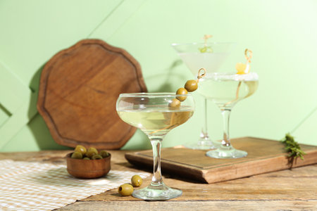 Glass of tasty martini and olives on wooden tableの写真素材