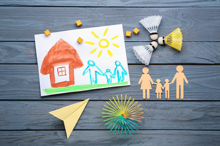Drawing with family figure and toys on dark wooden background. Children's Day celebrationの写真素材