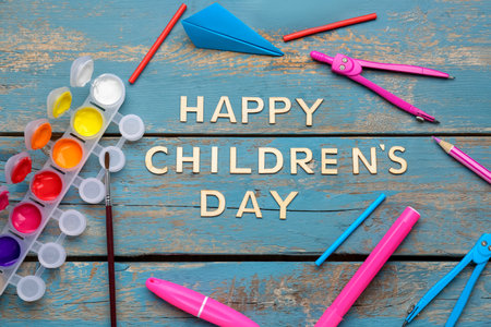 Text HAPPY CHILDREN'S DAY with school stationery on color wooden backgroundの写真素材