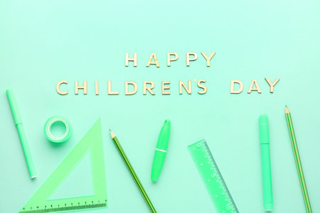 Text HAPPY CHILDREN'S DAY with school stationery on green backgroundの写真素材