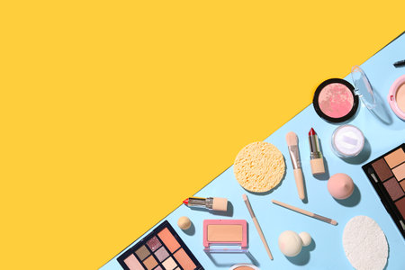 Decorative cosmetics with makeup brushes and sponges on color backgroundの写真素材
