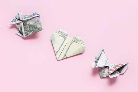 Origami made of dollar banknotes on pink backgroundの写真素材