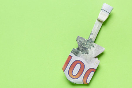 Origami guitar made of dollar banknotes on green backgroundの写真素材
