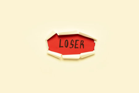 Word LOSER visible through hole in white paperの写真素材
