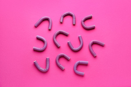 Hair curlers on pink backgroundの写真素材
