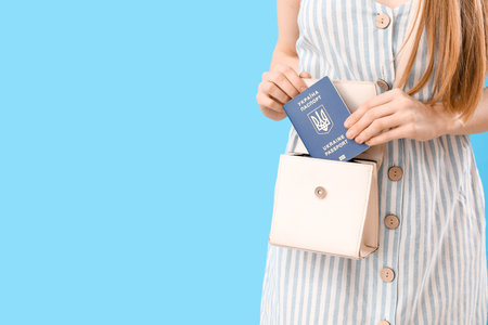 Woman Ukrainian passport in bag on blue background, closeupの写真素材