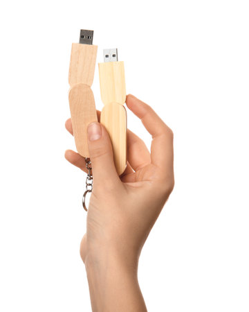 Female hand holding wooden USB flash drive isolated on white backgroundの写真素材